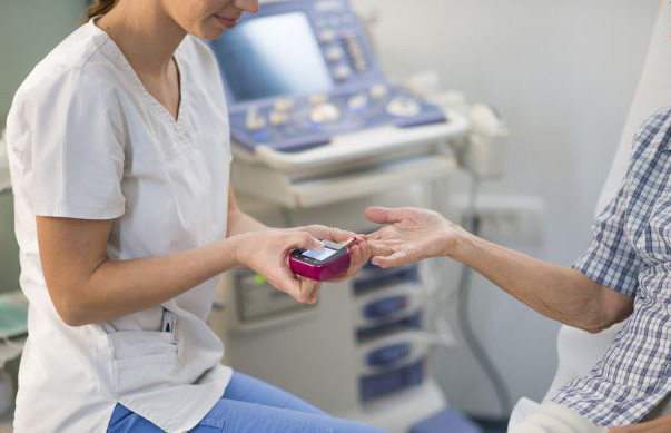 Nurse checking senior woman's blood sugar at diagnostic center.